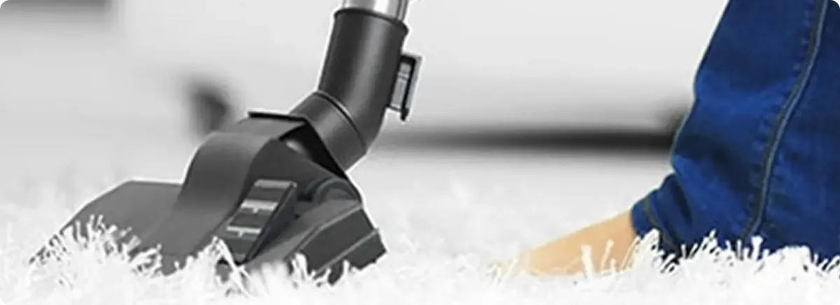 Close-up of a professional vacuuming a white carpet in Ellenton.